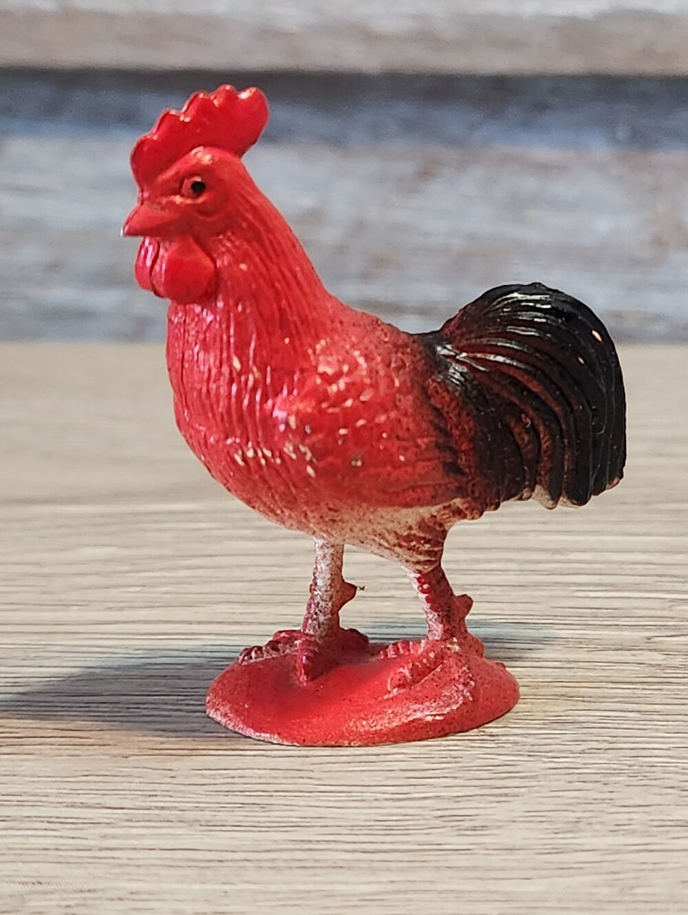 Red rooster figurine with black tail feathers